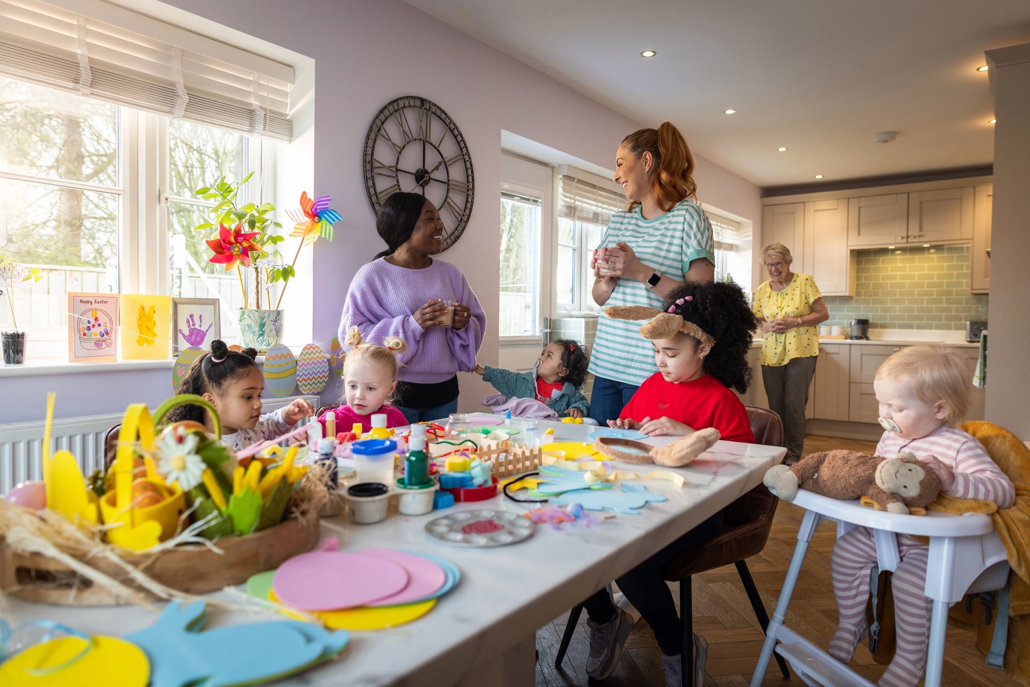 Niñas realizando manualidades acompañadas por sus madres