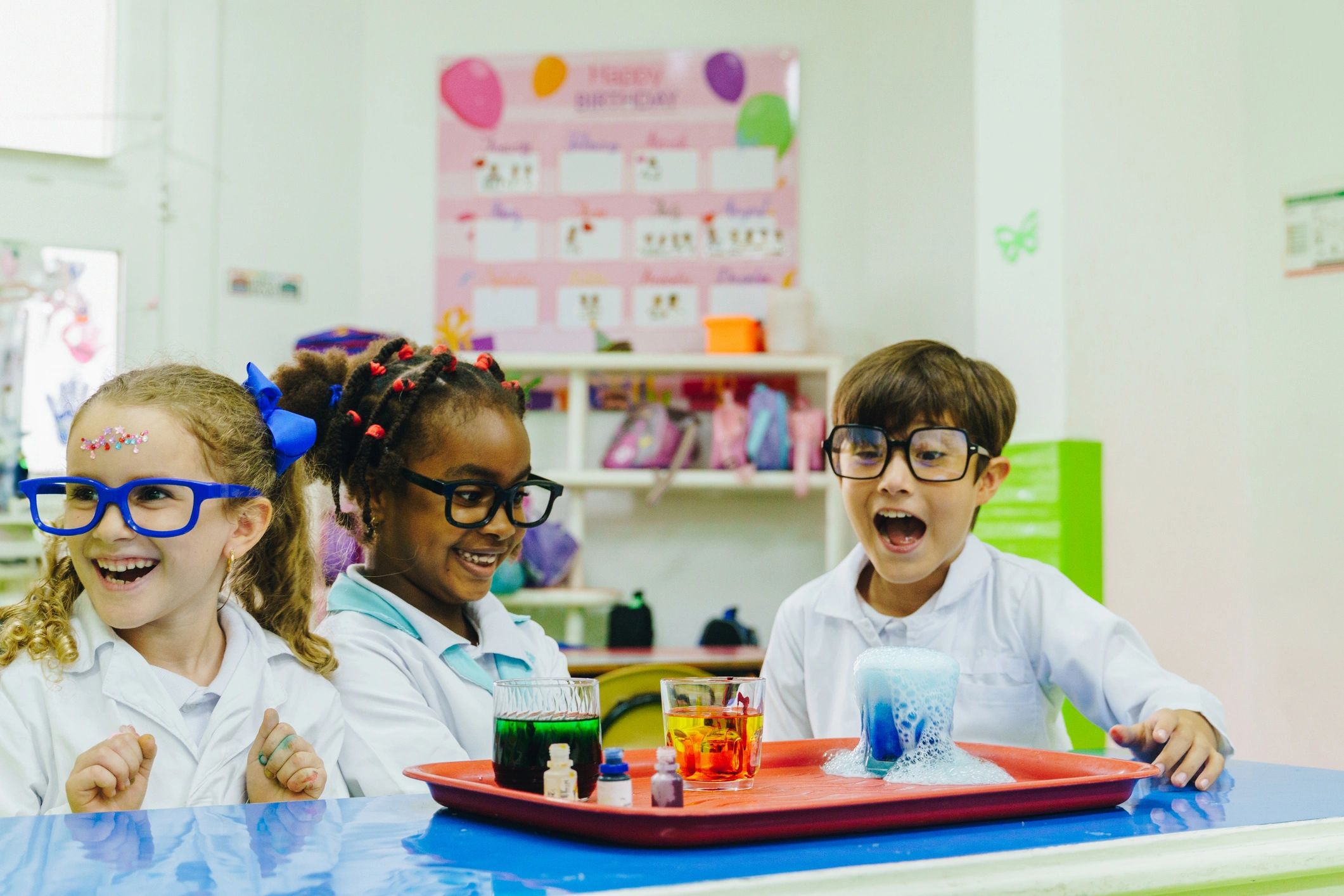 Niños disfrutando un experimento científico en laboratorio escolar