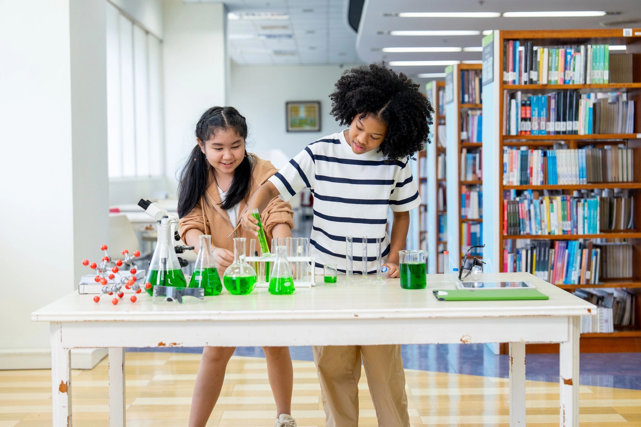Niñas realizando un experimento científico con tubos de ensayo