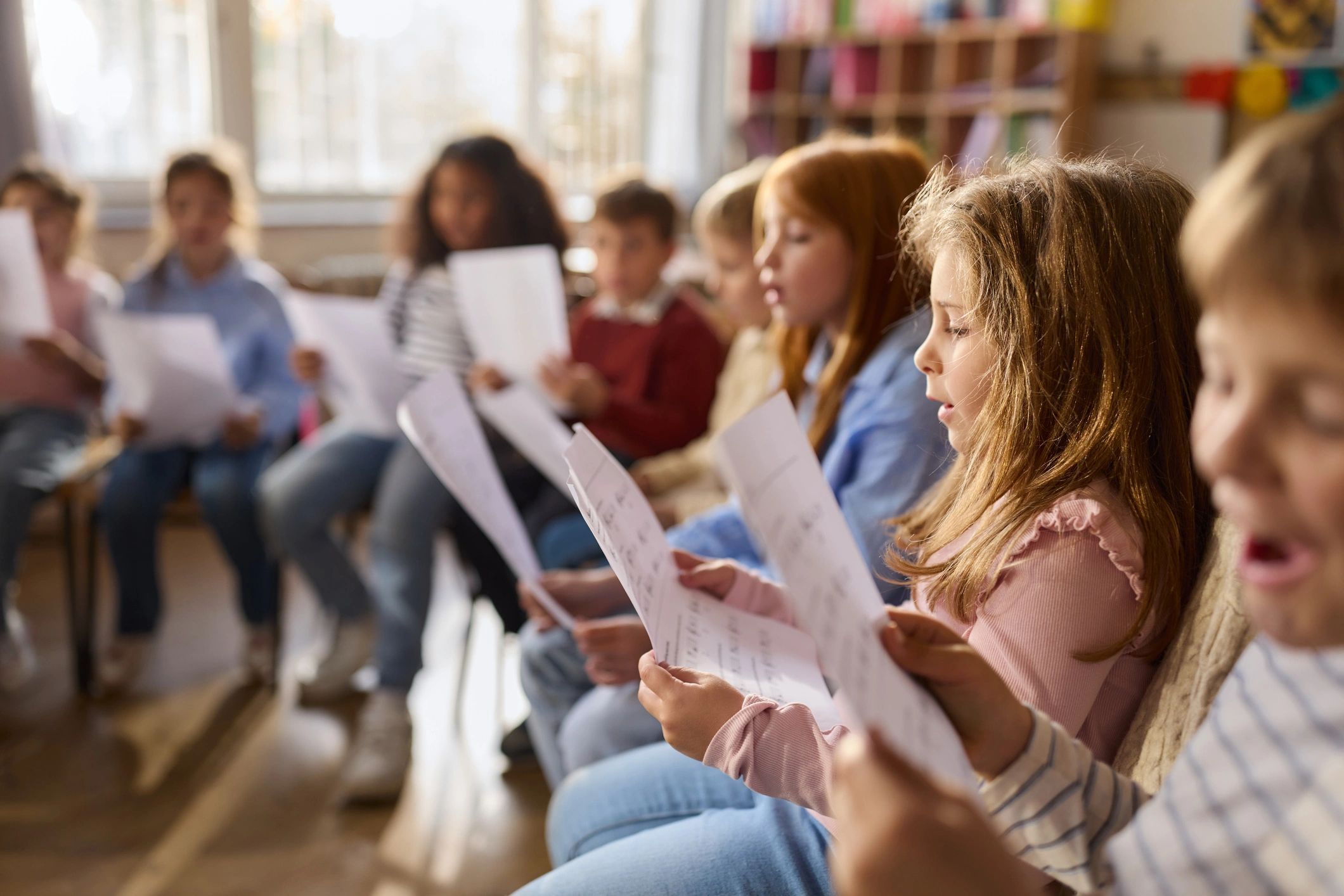 Niños cantando y actuando en un salón escolar